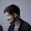黄果tv技术负责人周叙在多台设备前测试站点移动端适配与加载速度的工作画面，桌面上同时摆放着手机与平板